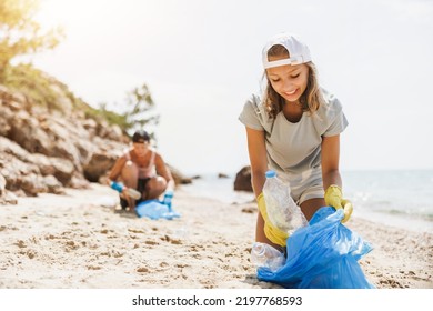 Teenager volunteers cleaning the sea beach by collecting garbage into plastic bag. - Powered by Shutterstock