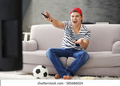 Teenager Watching Football Match At Home