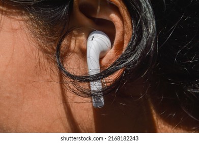 Teenager is wearing a headset on his ear.