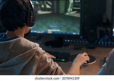 Teenager wearing a headset and playing online video games at home, 3D shooter games - Shutterstock ID 2078941309