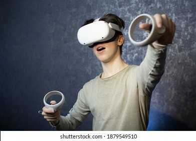 A teenager wearing virtual reality glasses .A young man uses a VR headset helmet to play games. View virtual reality videos . Technologies of the future. - Powered by Shutterstock