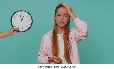 Teenager Young Girl With Anxiety Checking Time On Clock, Running Late To Work, Being In Delay, Deadline. Student Child Kid Looking At Hour, Minutes, Worrying To Be Punctual On Blue Studio Background