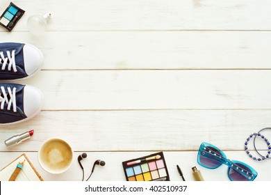 Teenager, Young Woman Or Girl Background. Blue Sneakers, Perfume, Cosmetics, Sunglasses, Sketchbook, Headphones, Coffee. Overhead Of Essentials For Modern Student.