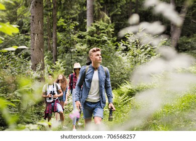 Teenagers With Backpacks Hiking In Forest. Summer Vacation.