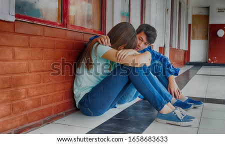 Teenagers couple at school. Boy conforting sad girl.