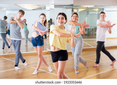 Teenagers in dance hall studying new movements, smiling and having fun - Powered by Shutterstock