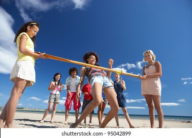 Teenagers Doing Limbo Dance On Beach