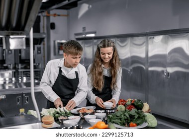 Teenagers learn from expert chefs at culinary school to prepare ingredients and create a variety of tasty meals. A practical activity connected their senses of taste and smell is making hamburgers. - Powered by Shutterstock