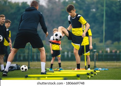 Teenagers on soccer training camp. Boys practice football with young coaches. Junior level athletes improving soccer skills on outdoor training. Player kick soccer ball to coach and ladder skipping - Shutterstock ID 1806669748
