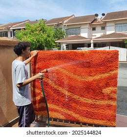 Teenagers Outdoor Activity During Pandemic Covid-19. Washing And Drying Carpet Under The Hot Sun. Home Area. Schools Are Closed. Concept Students Mental Health And Fresh Air. Malaysia. August 2021