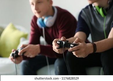 Teenagers playing video games at home - Shutterstock ID 1176828529