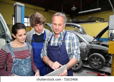 Teenagers in professional training with garage woner - Powered by Shutterstock