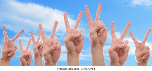 Teenagers raising their hands with two finger symbolizing peace