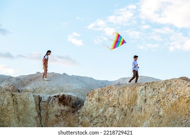 Teenagers Run Through Mountains With Kite Flying Summer Vacation Concept.