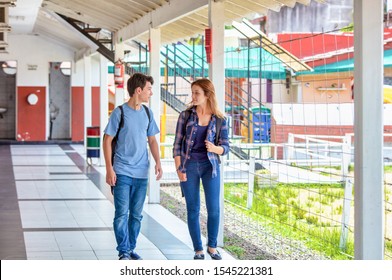 Teenagers At School. Couple Of Caucasian Girl And Boy Talking In The Hallway.