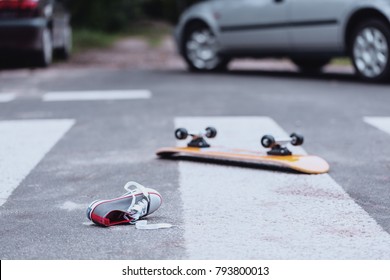 Teenager's Shoe And Skateboard Lying On A Pedestrian Crossing After Traffic Accident