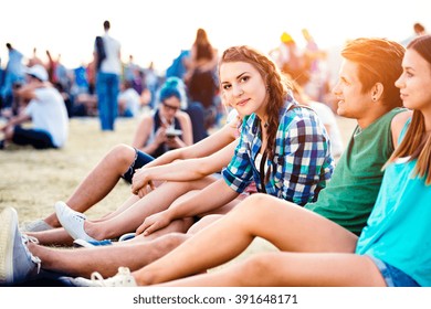 Teenagers at summer music festival, sitting on the ground - Powered by Shutterstock