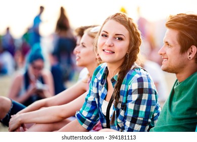 Teenagers at summer music festival, sitting on the ground - Powered by Shutterstock