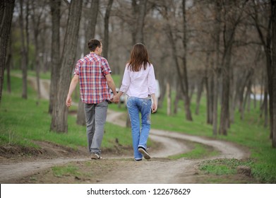 Teenagers Walking Away Along Forest Path