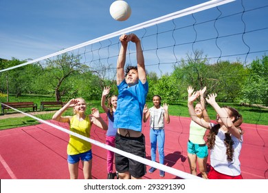 Teens all are with arms up play volleyball