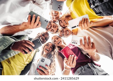 Teens in circle holding smart mobile phones - Multicultural young people using cellphones outside - Teenagers addicted to new technology concept - Powered by Shutterstock