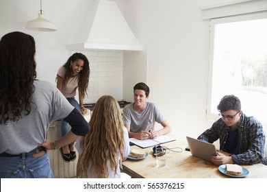 Teens Hanging Out In Kitchen, Doing Homework And Talking