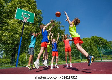 Teens In Jump Playing Basketball Game Together