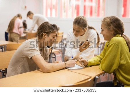 Teens performing group tasks and talking about solving.