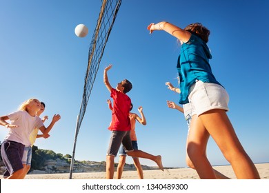 Teens playing volleyball during summer vacation on the beach