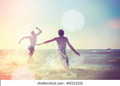 Teens Running Into The Waves At The Beach, Instagram Filter.