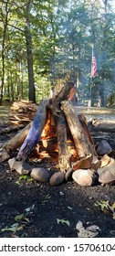 Teepee Fire Lay With Raised American Flag In The Background Scene.