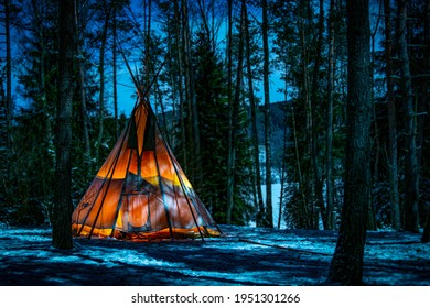 Teepee uder the blue sky in the snowy woods
