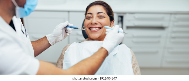 Teeth checkup at dentist's office. Smiling woman in dental clinic with doctor.