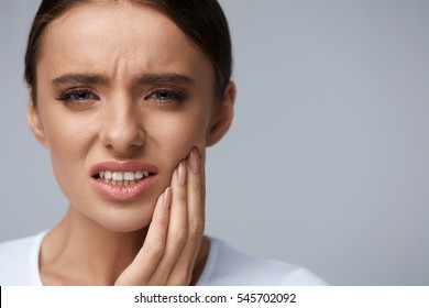 Teeth Problem. Woman Feeling Tooth Pain. Closeup Of Beautiful Sad Girl Suffering From Strong Tooth Pain. Attractive Female Feeling Painful Toothache. Dental Health And Care Concept. High Resolution