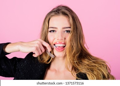 Teeth retainer for improving bite. Teeth care. Sensative woman holds teeth retainer. Mobile orthodontic appliance. Close-up of woman holds transparent teeth aligner.
