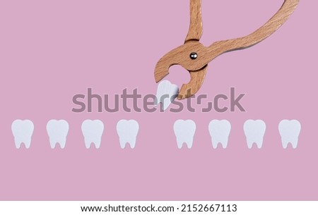 Teeth row and forceps for tooth extraction. Oral health problems and dentist work concept on pastel background. Children game at doctor. High quality photo