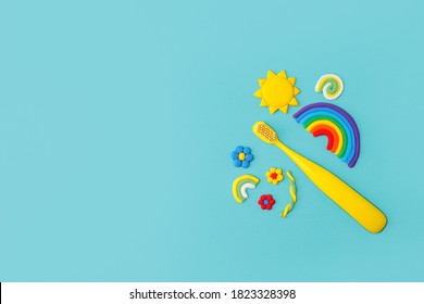 Teeth With Sweet Candies And Colorful Toys On Blue Backgrouns. Tooth Caries In Children's, Dental Healthcare, Toothpaste And Toothbrush. Routine Hygiene For Kids, Nobody, Copy Space, Flyer