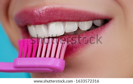 Teeth with tooth brush. Clean teeth. Perfect womans smile. Healthy white theeth. Beauty woman with perfect lips and smile. Dental care and teeth whitening. Close-up of perfect smile with tooth brush