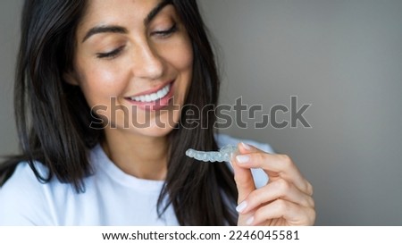 Teeth whitening. Woman with white smile holding removable braces . Invisible teeth tray . Orthodontic silicone trainer. Invisible braces aligner. 