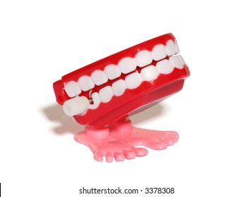A teeth wind up toy over white