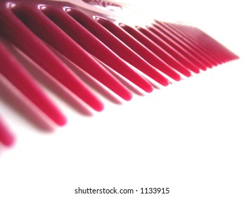 Teeth of a wine-colored, plastic comb
