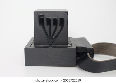Tefillin -[Jewish phylactery] with black straps on a white background.
Two black boxes, one with the Hebrew letter Shin on the side, long ribbons. Jewish traditional religious items for male prayers
