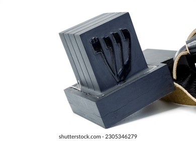 Tefillin or phylacteries . Pair of black leather boxes for the arm and for the head with leather strips containing Torah verses that are worn Jewish men prayers. One box with hebrew letter Shin.