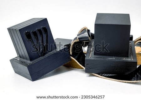 Tefillin or phylacteries . Pair of black leather boxes for the arm and for the head with leather strips containing Torah verses that are worn Jewish men prayers. One box with hebrew letter Shin.
