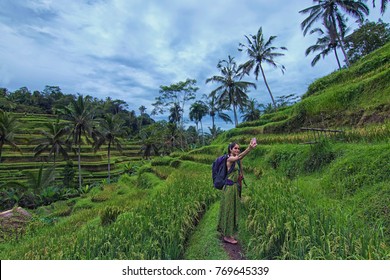 Tegalalang, Bali - November 24th, 2017: A Female Tourist Taking A Selfie With Tegalalang Paddy Fiels As The Background. Tegalalang Is One Of Bali Top Tourist Spot.