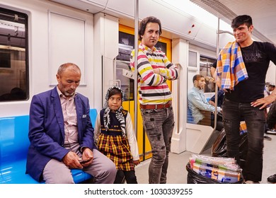 Tehran, Iran - April 29, 2017: Iranian men and a little girl in a religious veil ride in a subway car. - Shutterstock ID 1030339255