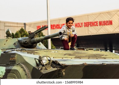 Tehran, Iran - November 2019. Iranian Child Are Sitting On The Tank In The Islamic Revolution And Holy Defense Museum.