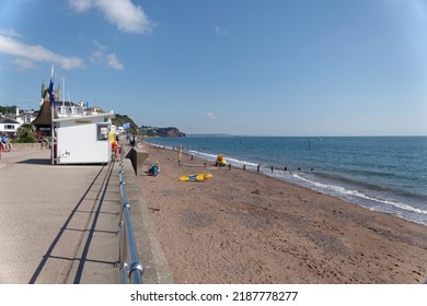 Teignmouth Devon England May 2022. The Esplanade And Red Sandy Beach During The  Busy Holiday Season . Partial View Of The Town