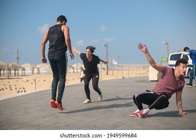 Tel Aviv –March 12th 2021: Capoeira group training at the beach promenade. Couples of young Israeli practitioners playing with each other.