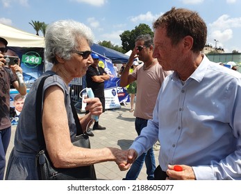 Tel Aviv, Israel - August 10, 2022: Economist Avraham Avi Simhon (Simchon) And Old Woman Voter Shaking Hands. Likud Party Primary Election At Menora Mivtachim Arena.